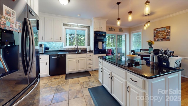 kitchen featuring pendant lighting, black appliances, sink, crown molding, and white cabinets