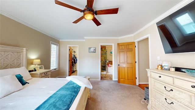 bedroom with a walk in closet, a closet, ceiling fan, light colored carpet, and crown molding