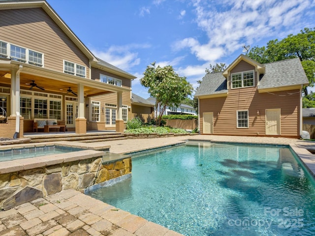 view of swimming pool featuring a patio area, ceiling fan, and french doors