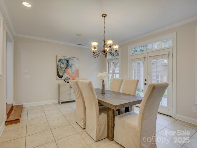 dining room with a notable chandelier, ornamental molding, light tile patterned floors, and french doors