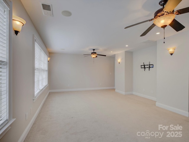 carpeted spare room with ceiling fan