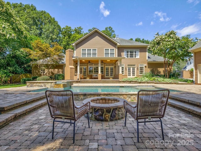 rear view of house featuring a fire pit, ceiling fan, a patio, and french doors