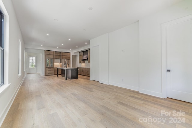 unfurnished living room with sink and light hardwood / wood-style flooring