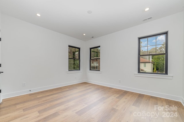 spare room with light wood-type flooring and a healthy amount of sunlight