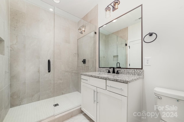 bathroom with toilet, an enclosed shower, and vanity