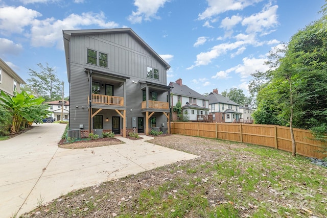 rear view of property with a balcony and central AC