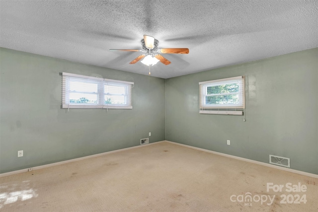 carpeted empty room featuring ceiling fan and a textured ceiling