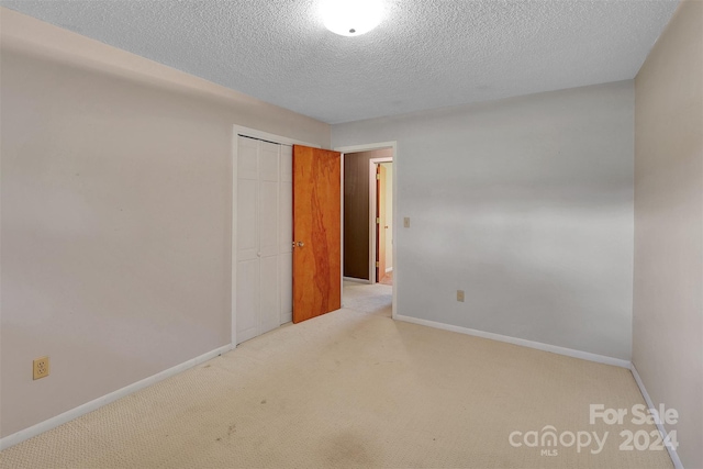 carpeted empty room with a textured ceiling