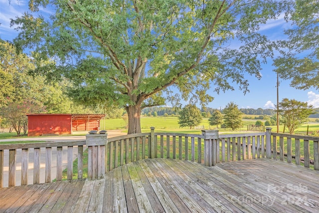 wooden terrace featuring an outbuilding and a lawn