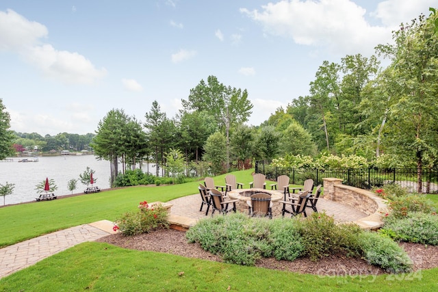 view of home's community with a patio, a water view, a fire pit, and a lawn