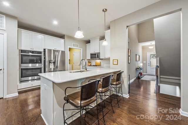 kitchen with stainless steel appliances, dark hardwood / wood-style floors, white cabinets, backsplash, and kitchen peninsula