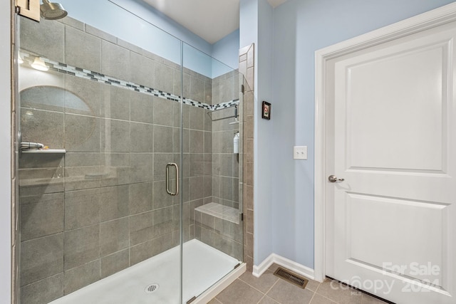 bathroom with tile patterned floors and a shower with shower door