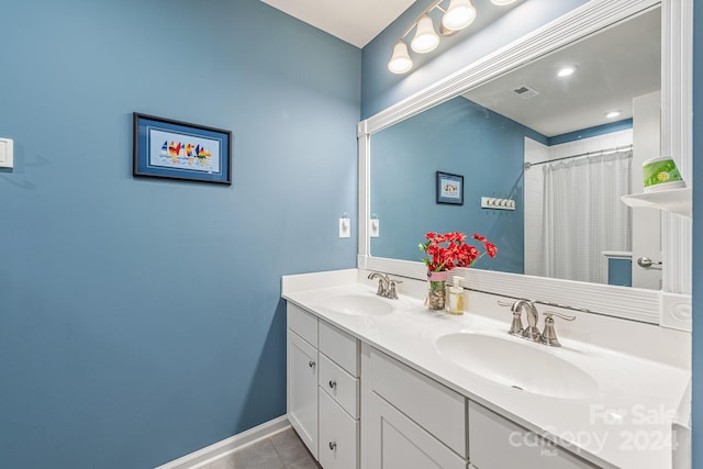 bathroom with tile patterned floors and dual vanity