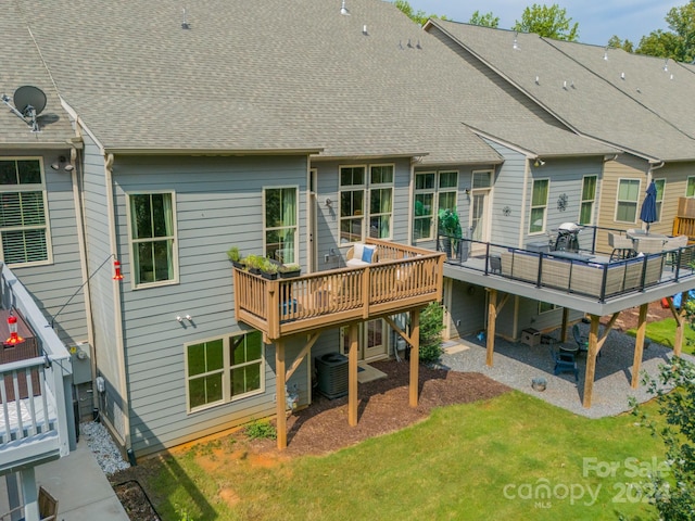 rear view of house featuring a wooden deck, cooling unit, and a yard