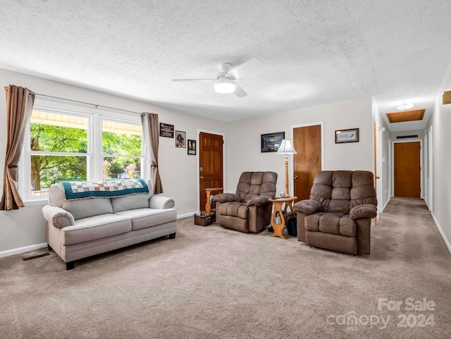 living area with carpet flooring, ceiling fan, visible vents, and baseboards