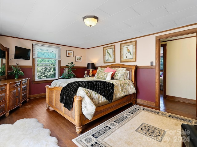 bedroom featuring ornamental molding and dark hardwood / wood-style flooring