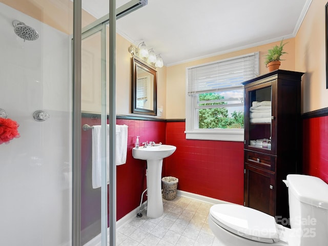 bathroom with tile walls, ornamental molding, a shower stall, and toilet