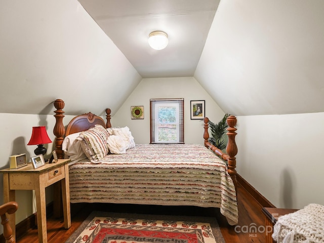 bedroom with wood finished floors and lofted ceiling