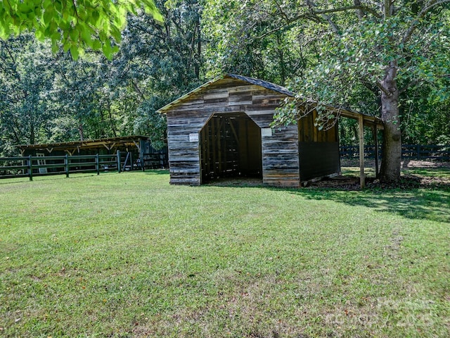view of pole building with fence and a yard