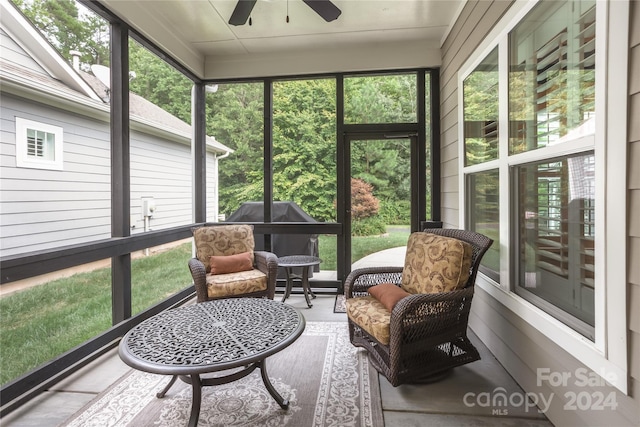 sunroom / solarium featuring a ceiling fan