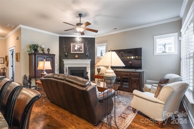 living room featuring ceiling fan, ornamental molding, and wood-type flooring