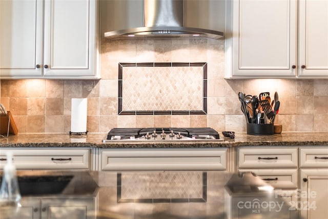 kitchen featuring wall chimney range hood, tasteful backsplash, and stainless steel gas cooktop