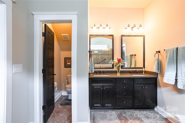 bathroom featuring toilet, double vanity, and tile patterned flooring