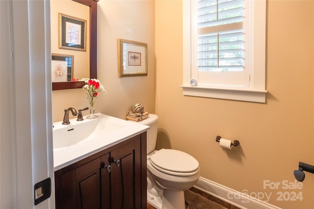 half bathroom with vanity and toilet