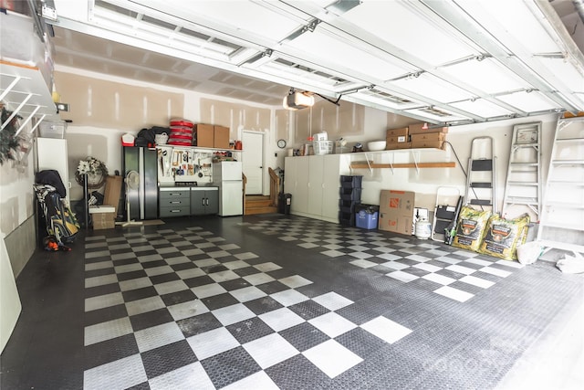 garage featuring a garage door opener and freestanding refrigerator