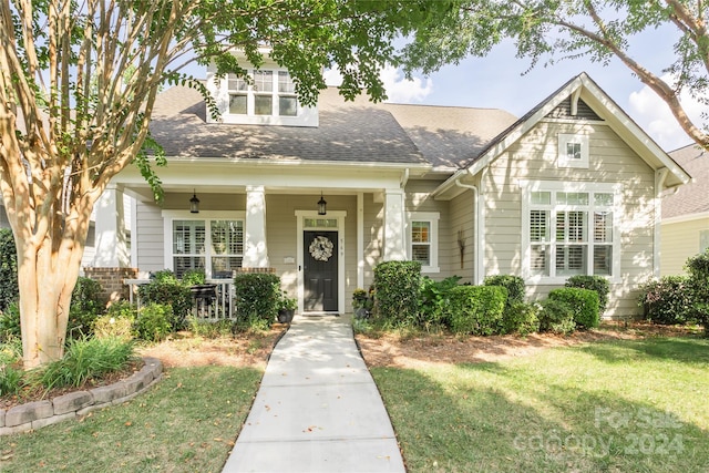 view of front of house with a front yard and a porch