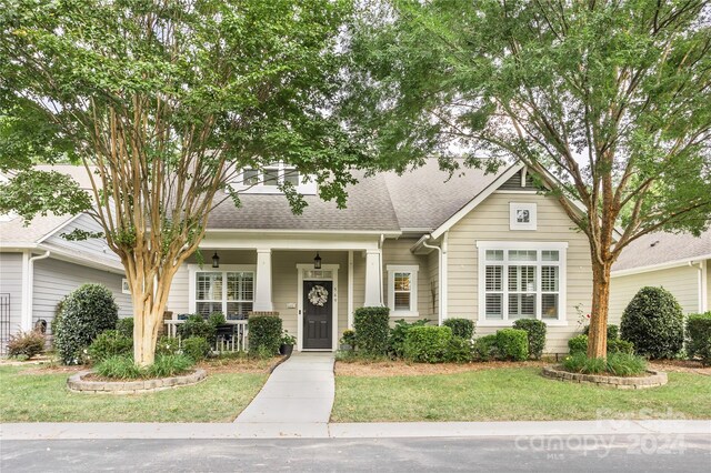 view of front of property with covered porch and a front yard