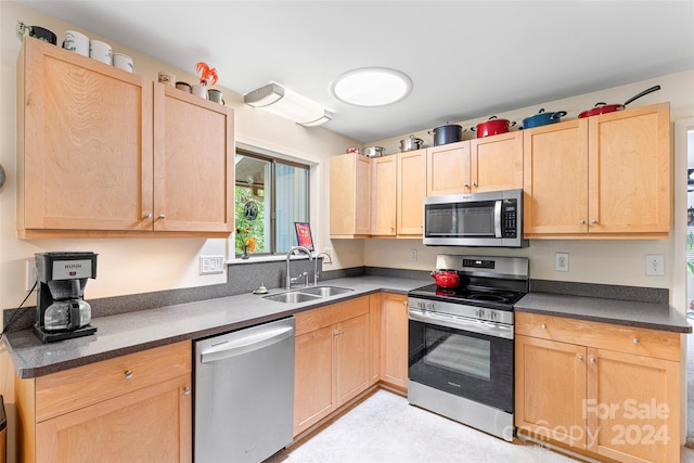 kitchen featuring appliances with stainless steel finishes, sink, and light brown cabinets