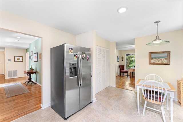 kitchen featuring light wood-type flooring, stainless steel refrigerator with ice dispenser, and decorative light fixtures