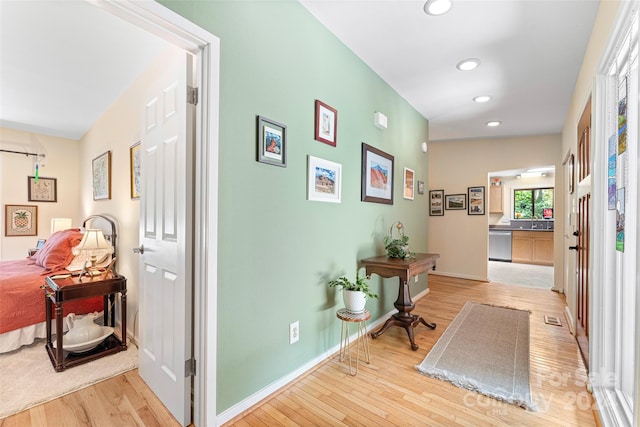 hall with sink and light wood-type flooring