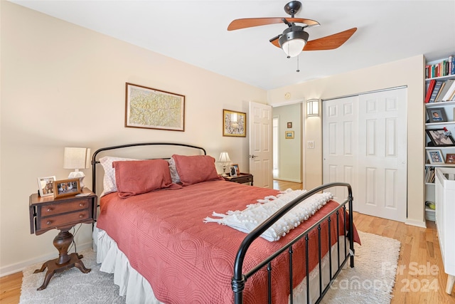 bedroom with ceiling fan, light wood-type flooring, and a closet