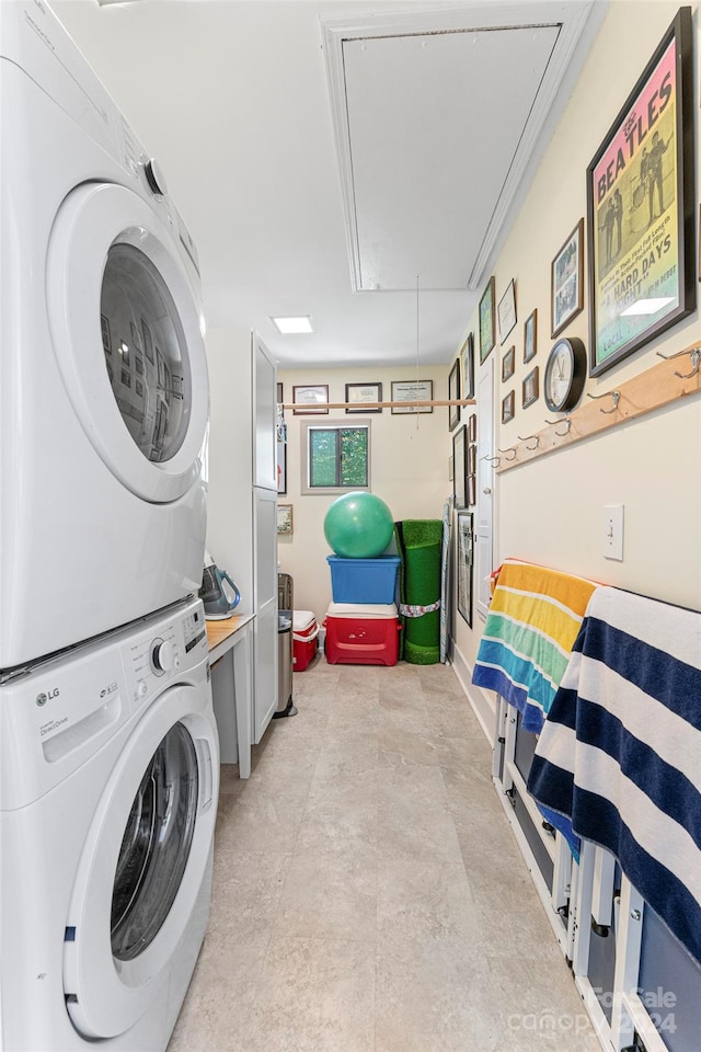 laundry area featuring stacked washer and dryer and light tile patterned floors