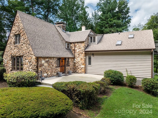 127 Springside Rd, Asheville, NC 28803 - rear view of house featuring a yard, stone siding, a chimney, and a patio