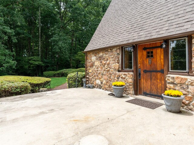 127 Springside Rd, Asheville, NC 28803 - doorway to property with stone siding, a patio, and a shingled roof