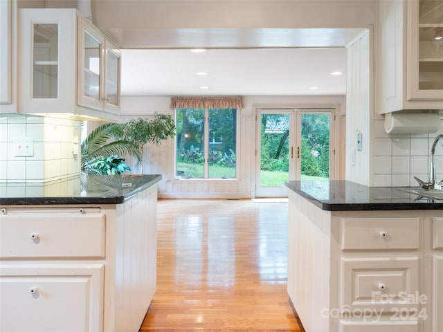 127 Springside Rd, Asheville, NC 28803 - kitchen with dark stone counters, a sink, glass insert cabinets, light wood-style floors, and backsplash