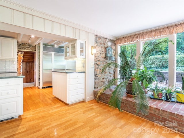 kitchen with light hardwood / wood-style flooring, decorative backsplash, built in refrigerator, and white cabinets