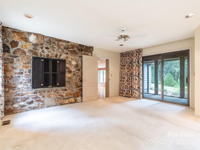 unfurnished living room with ceiling fan, a fireplace, and carpet flooring