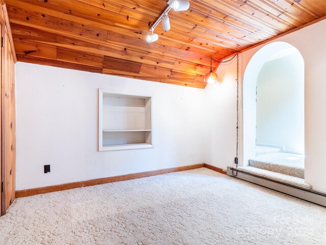 empty room featuring rail lighting, built in features, carpet flooring, and wood ceiling