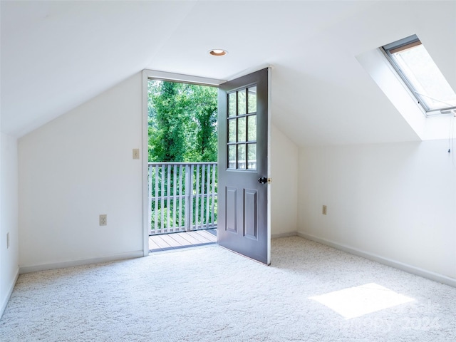 additional living space featuring lofted ceiling with skylight and carpet