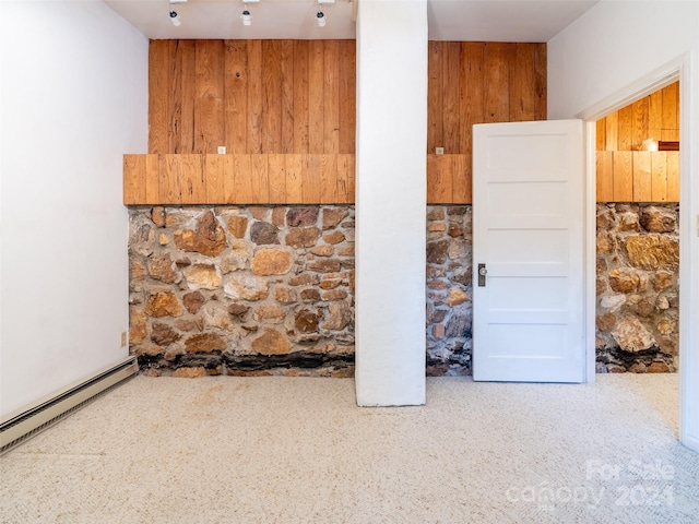 interior space with wood walls and a baseboard heating unit