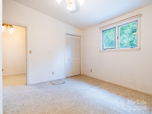 unfurnished bedroom with vaulted ceiling and a closet