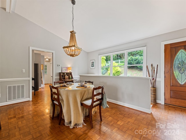 dining area featuring high vaulted ceiling, a chandelier, and parquet floors