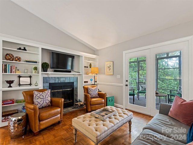 living room featuring a fireplace, lofted ceiling, and parquet floors