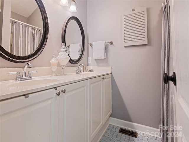 bathroom with double vanity and tile patterned flooring