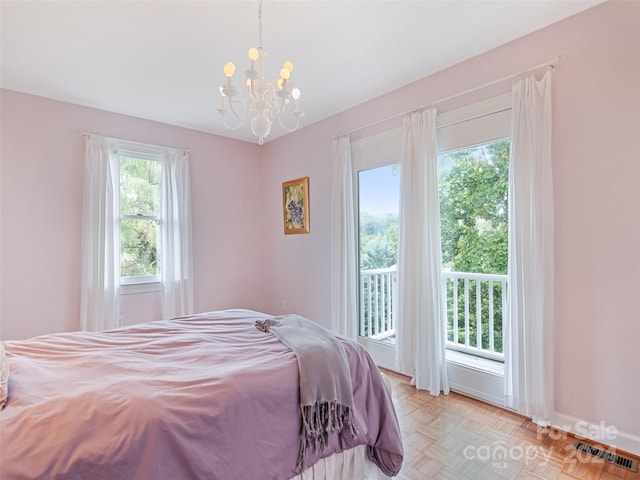 bedroom with access to exterior, a notable chandelier, light parquet floors, and multiple windows