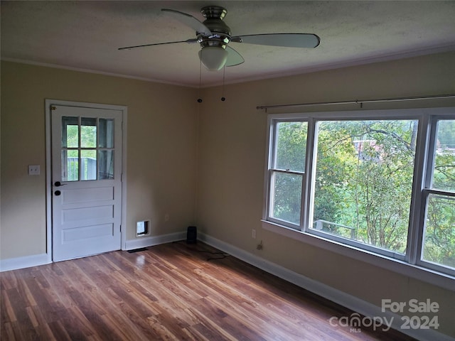 unfurnished room with ceiling fan, a wealth of natural light, hardwood / wood-style floors, and ornamental molding